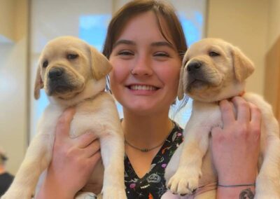 Woman holding yellow puppy gently