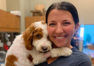 Woman smiling with brown white puppy